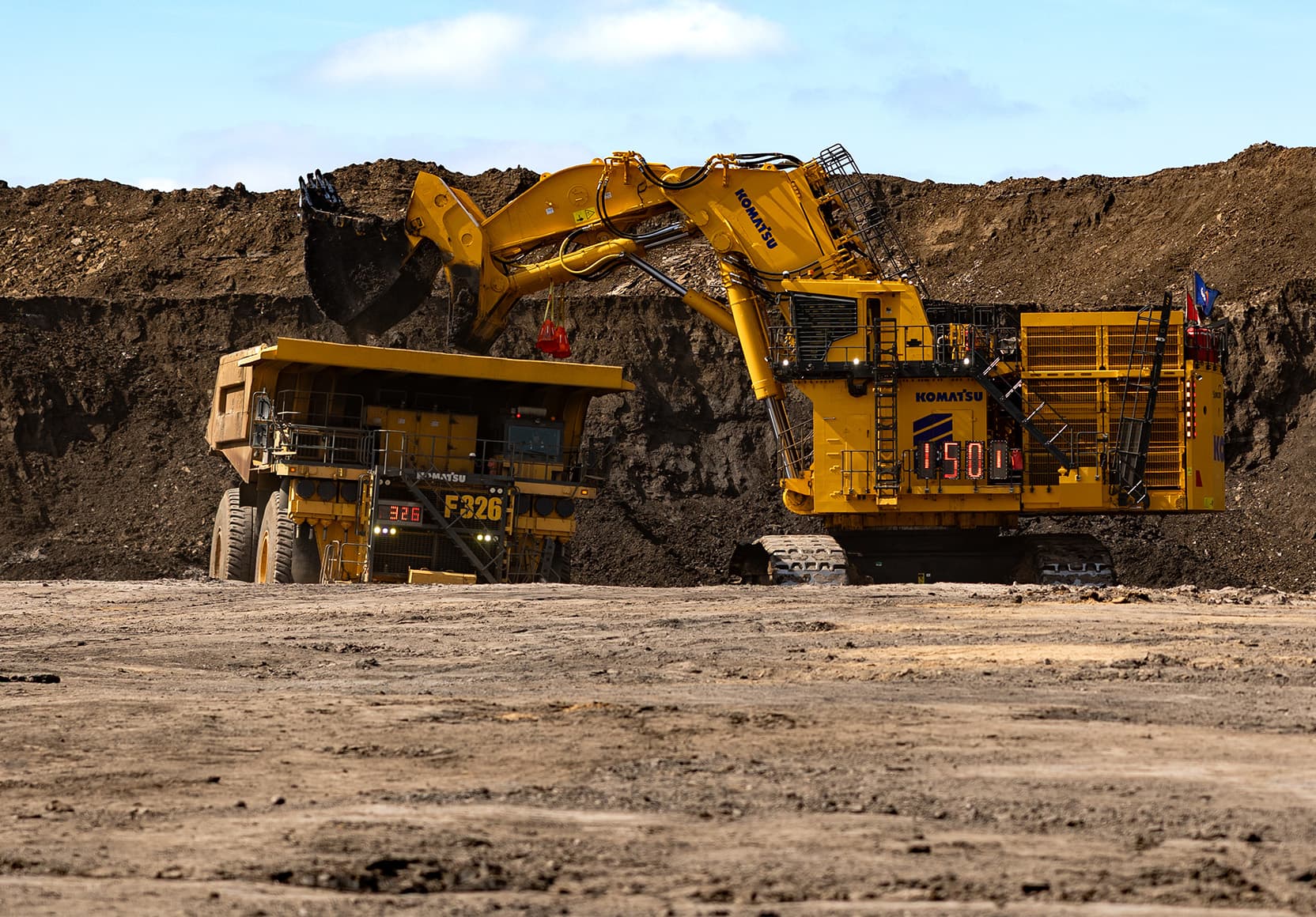 A Komatsu PC9000 shovel being operated at the Fort Hills mine. There is blue sky in the background.