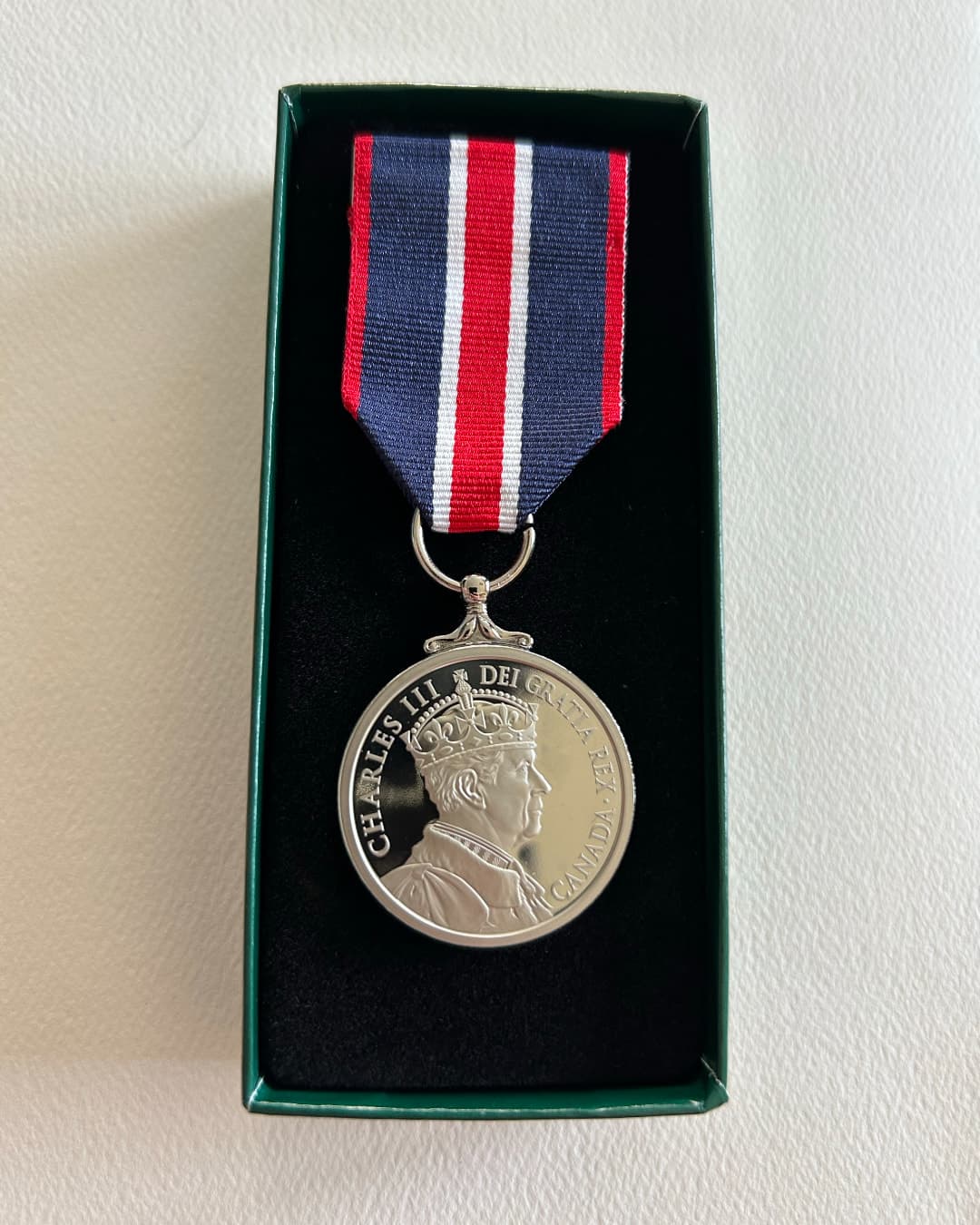 A close-up of Tara’s King Charles Coronation Medal, containing an engraving of King Charles III.