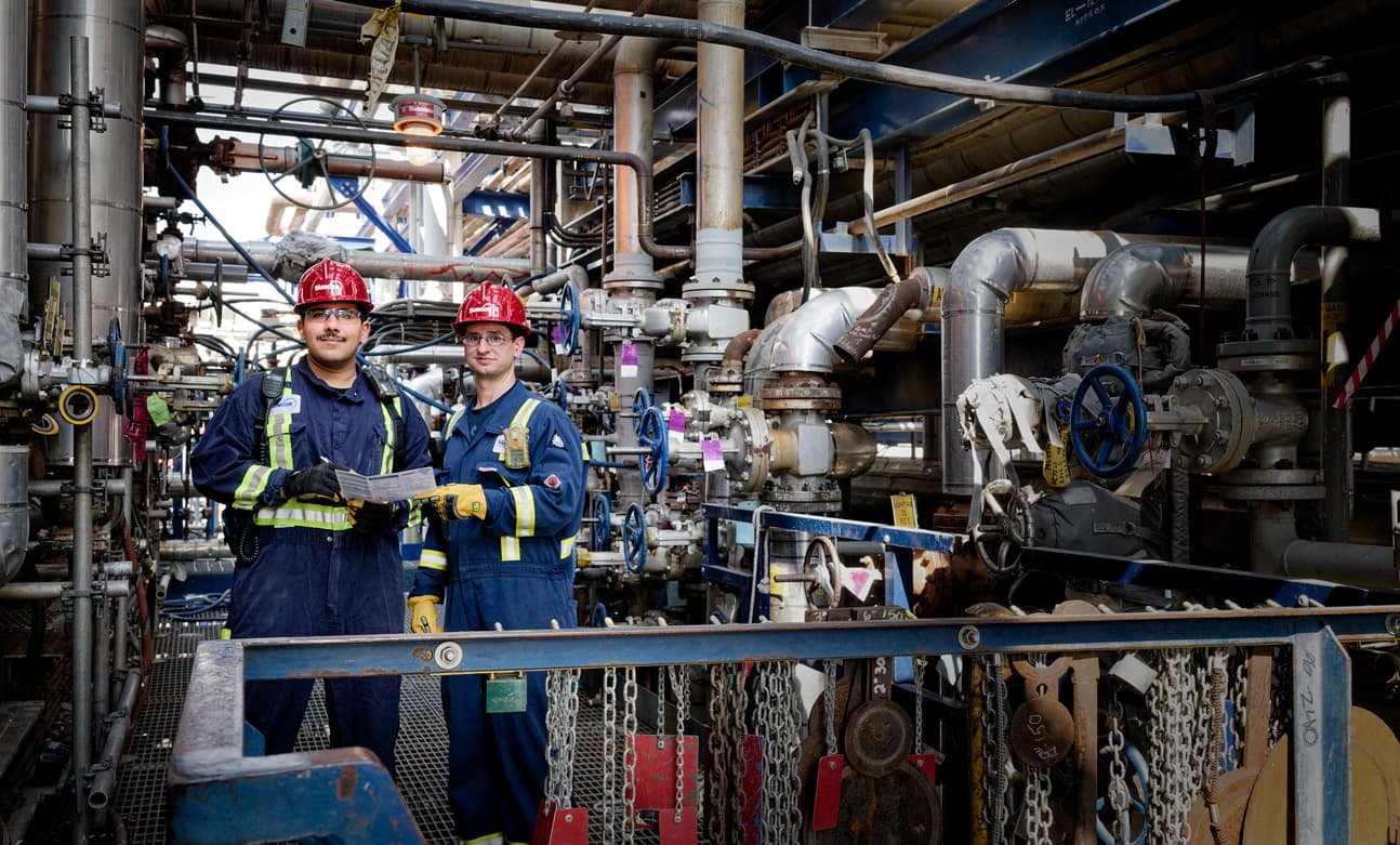 Employees wearing safety gear inspect equipment at Suncor’s Edmonton Refinery.
