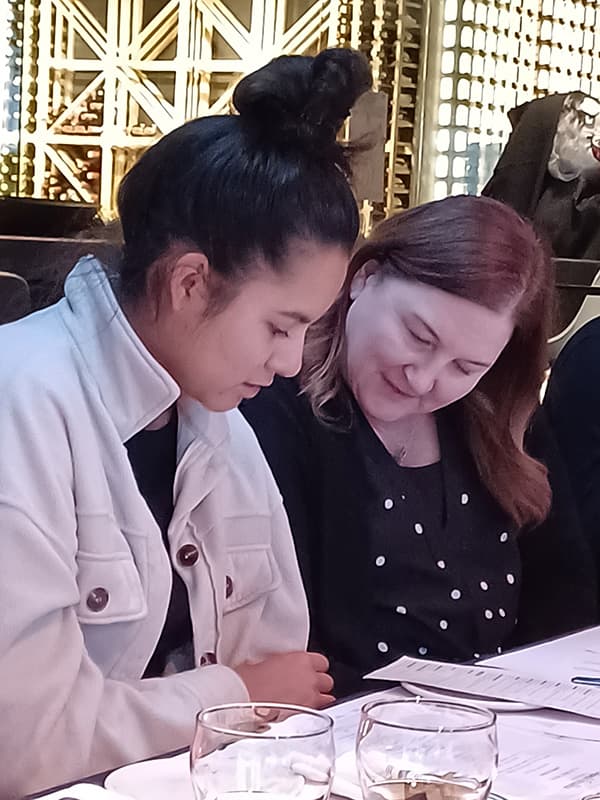Two people at a table reading a menu.