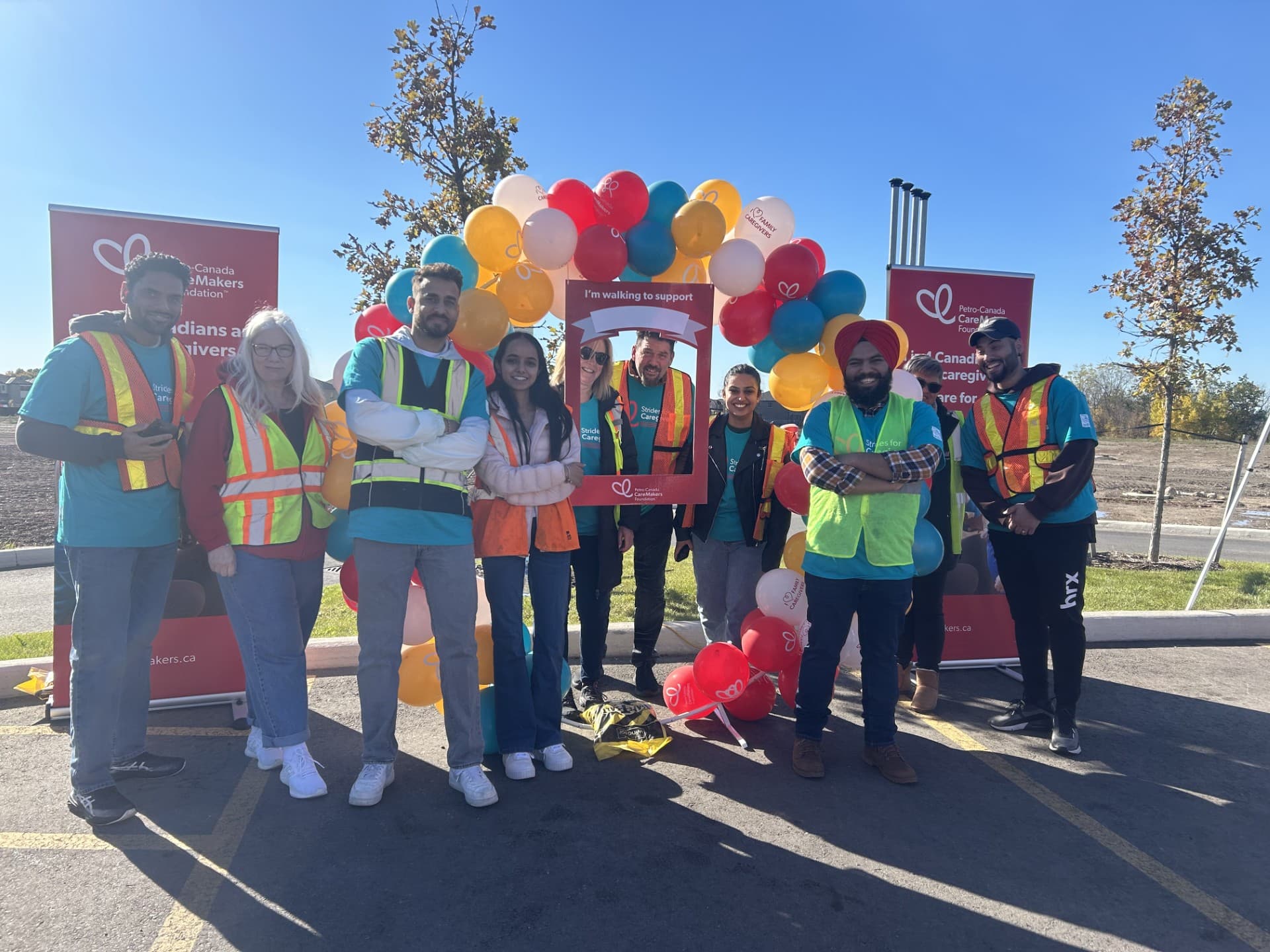 Un groupe de personnes se tient dans un stationnement avec des ballons.