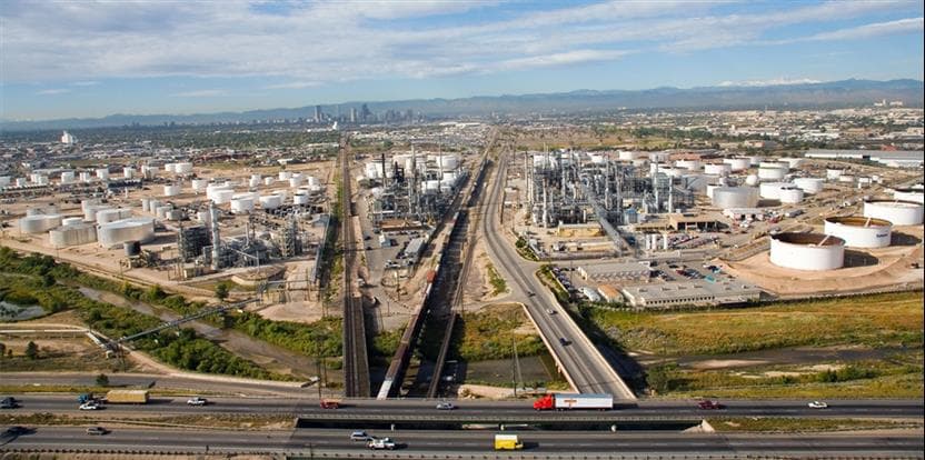 Aerial image of Commerce City refining operations with downtown Denver and the Rocky Mountains in the background.