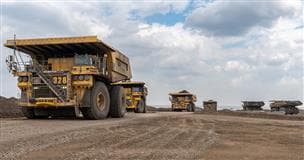 Des camions de transport autonome travaillant à la mine Millenium de l'usine de base.