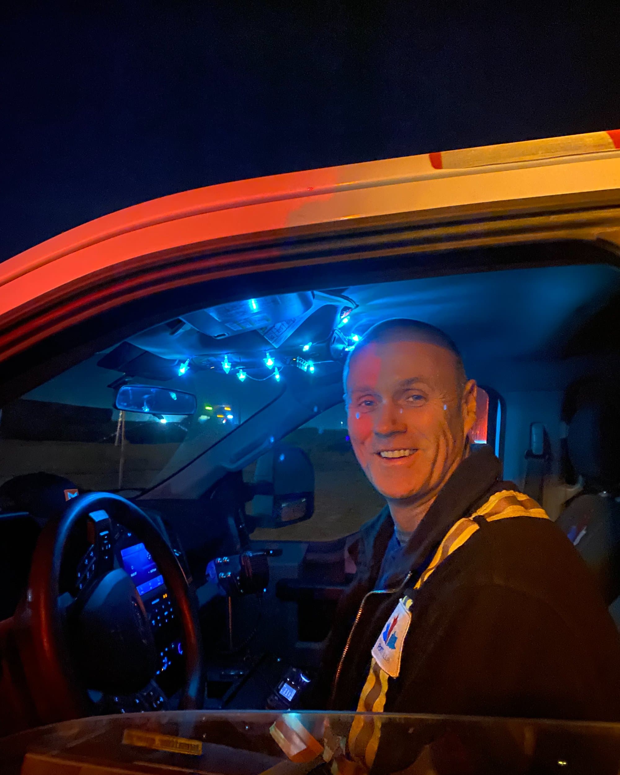 Un employé assis dans son véhicule à l'installation avec des lumières de Noël à l'intérieur.
