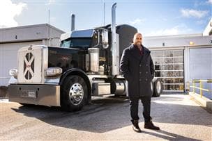 A Petro-Canada SuperPass member stands in front of a semi-truck