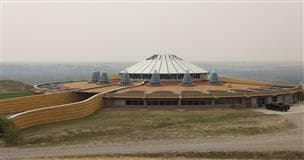 Un vaste édifice de forme circulaire surplombant la vallée de la rivière.