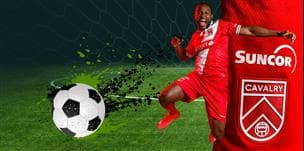 Un joueur du Cavalry FC portant un uniforme 2026 avec le logo de Suncor botte un ballon de soccer sur le terrain.