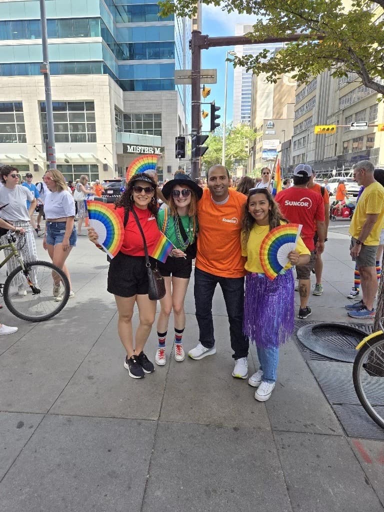 Asif (middle right) standing with three other employees at the Calgary Pride Parade.