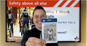Une femme posant avec une carte aide-mémoire avec une photo de son chien.