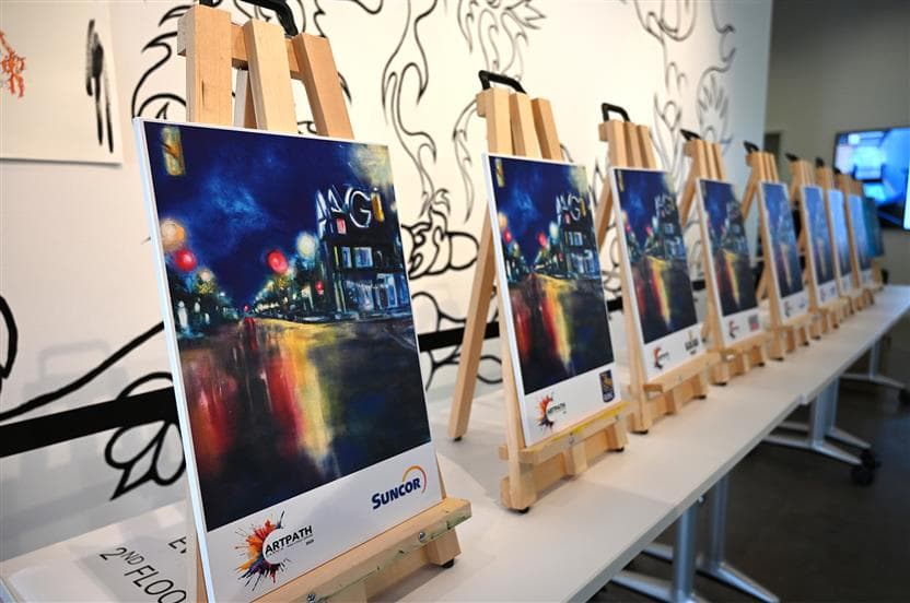 Chevalets d’art mis de l’avant, montrant des peintures d’un paysage en soirée.