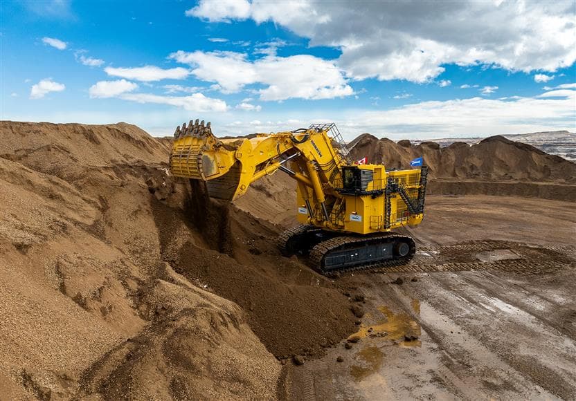 The PC9000 in a mining pit with blue skies in the background.
