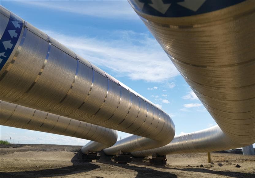 Une vue rapprochée de tuyaux en acier inoxydable. Il y a un ciel bleu en arrière-plan.