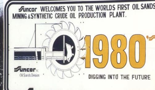 A sign welcoming visitors to Suncor’s crude oil production plant in northern Alberta. A bucketwheel is pictured with a large 1980, as well as the slogan “Digging into the future”.