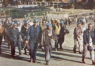 Une photo des années 1960 d'employés de Suncor qui marchent à l'extérieur en ÉPI.