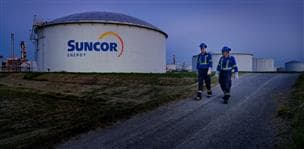 Workers walking by storage tanks at the Sarnia Refinery